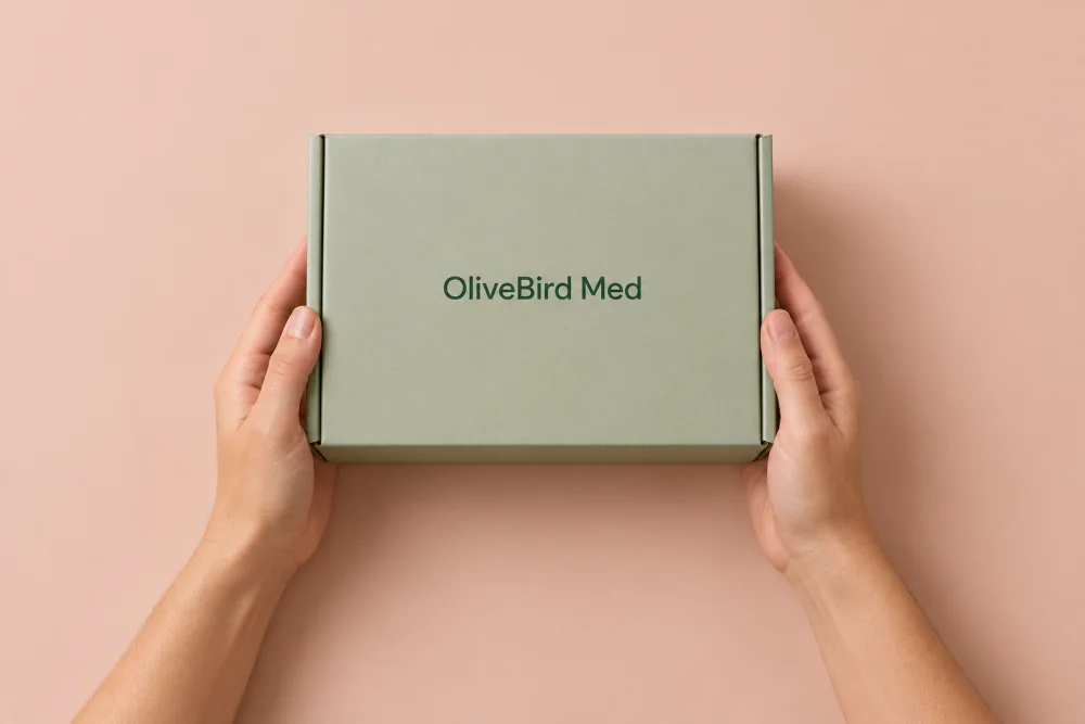 Hands holding an illustrative sage OliveBird Med shipping box